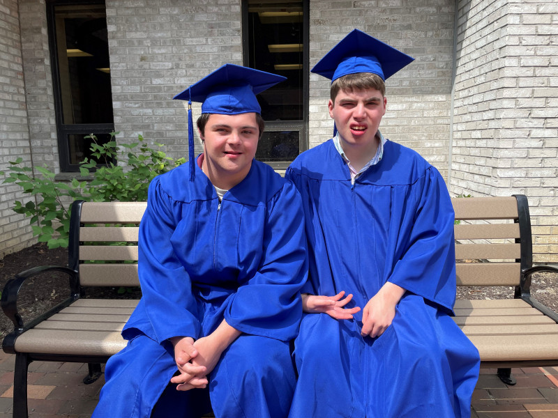 Vinny-luke-sit-on-bench-with-cap-and-gown